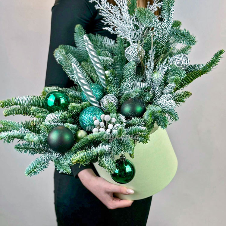Зеленая новогодняя композиция в коробке (в руках флориста)